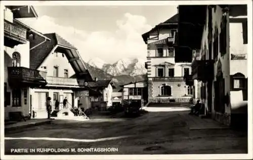 Ak Ruhpolding in Oberbayern, Straße in  Gebäude, Berge im Hintergrund