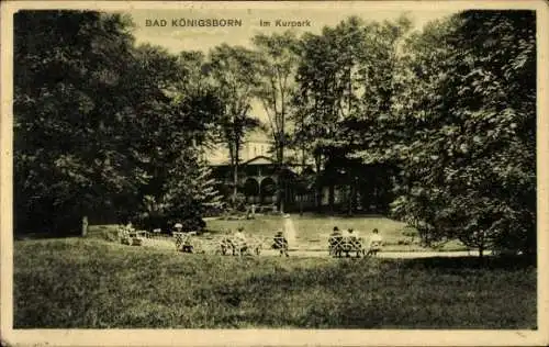 Ak Königsborn Unna im Ruhrgebiet, Kurpark, Bäume, Sitzbänke, Menschen, Gebäude im Hintergrund