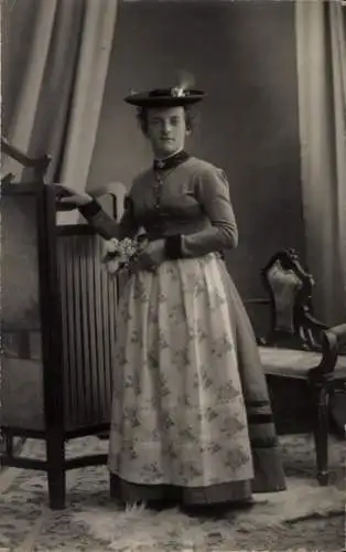 Ak Bichl in Oberbayern, Eine junge Frau in bayerischer Tracht steht vor einem Schrank.