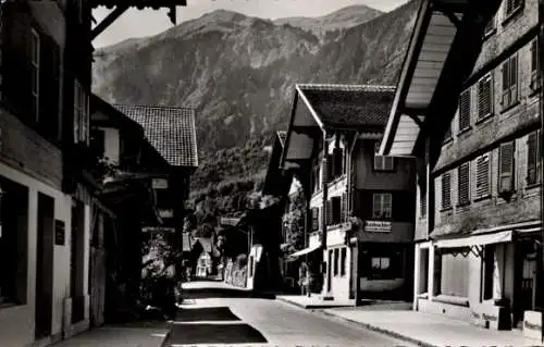 Ak Brienz Kanton Bern, Dorfansicht mit traditionellen Häusern, Berglandschaft im Hintergrund