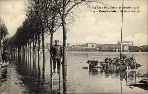 Ak Courbevoie Hauts de Seine, Überschwemmung, Januar 1910, Mann auf Baumstamm, geflutete Straße