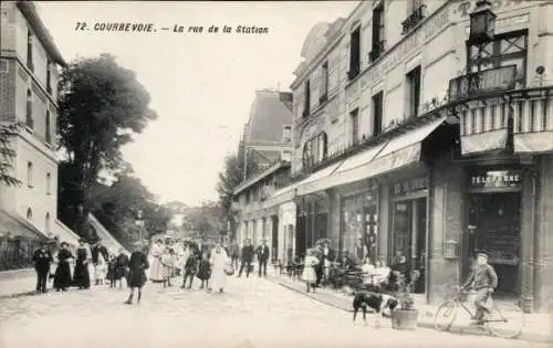 Ak Courbevoie Hauts de Seine, La rue de la Station, Telephone, Mann mit einem Fahrrad