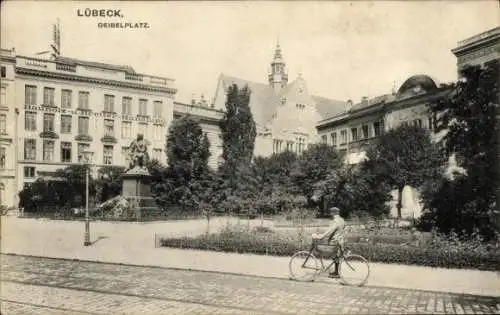 Ak Lübeck in Schleswig Holstein, Partie am Geibelplatz,Denkmal, Fahrrad,Bahnholz und Bretterhandlung