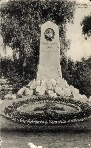 Ak Senftenberg in der Niederlausitz, Friedrich Ludwig Jahn Denkmal, Denkmal aus Steinen, Blumenbe
