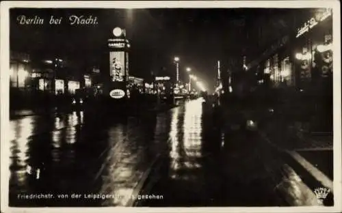 Ak Berlin Friedrichshain, Berlin bei Nacht, Friedrichstr., beleuchtete Straßen, Plakatwerbung