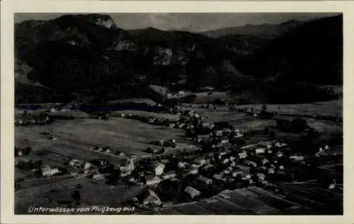 Ak Unterwössen in Oberbayern, Luftaufnahme, Berglandschaft, kleine Ortschaft, Gebäude