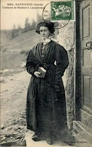 Ak Lanslebourg Savoie, Maurienne, Eine Frau in traditioneller Tracht steht vor einer Tür.
