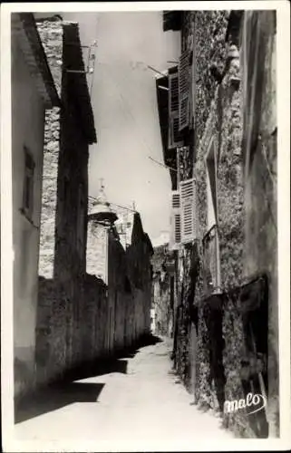 Ak Castellar Alpes Maritimes, Enge Gasse, alte Steinmauern, Fensterläden, sonnige Atmosphäre