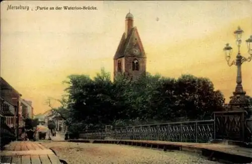 Ak Merseburg an der Saale, Wasserloo-Brücke, Kirche im Hintergrund, Laternen, belebte Straße