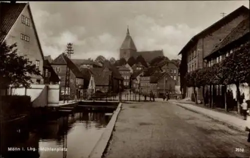 Ak Mölln im Herzogtum Lauenburg, Mühlenplatz,  Gebäude, Kirche im Hintergrund, Kanal