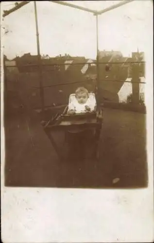 Ak Bischofswerda in Sachsen, Kind in Hochstuhl, Häuser im Hintergrund, sepiafarbig, nostalgisch