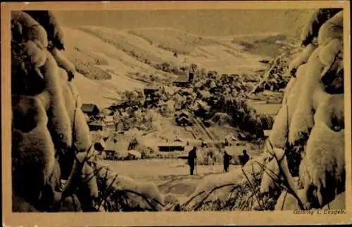 Ak Geising Altenberg im Erzgebirge, Schneebedeckte Landschaft, kleine Häuser, zwei Personen im Vo