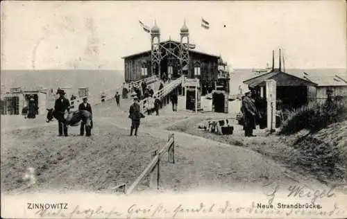 Ak Ostseebad Zinnowitz auf Usedom, Strandbrücke, Gebäude mit Türmen, Menschen auf dem Weg, 