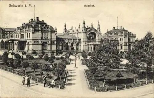 Ak Schwerin in Mecklenburg, Bahnhof,  Gebäude, Gartenanlage, Menschen auf der Straße