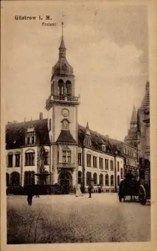 Ak Güstrow in Mecklenburg, Historisches Gebäude, Turm, Uhr, Pferd und Wagen, Straßenansicht