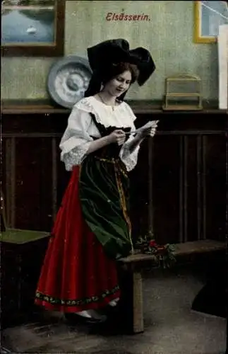 Ak Andlau Elsass Bas Rhin, Eine junge Frau in traditioneller elsässischer Kleidung liest einen...