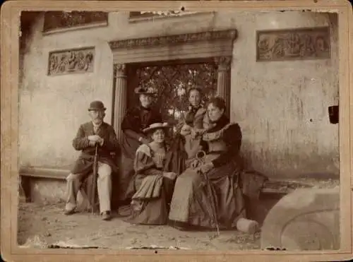 Foto Gruppenbild, Frauen und Mann vor einem Steintor