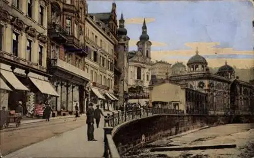 Ak Karlovy Vary Karlsbad Stadt, Vorderansicht eines Ufers, Geschäfte, Kirche, Spaziergänger, h...