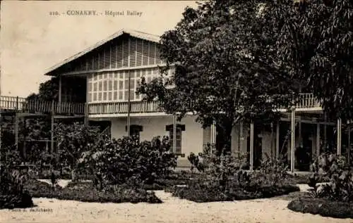 Ak Conakry Konakry Guinea, Hôpital Ballay, zweigeschossiges Gebäude, Gartenlandschaft, histori...