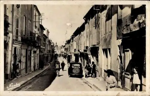Ak Castillonnès Lot et Garonne, Schmale Straße, alte Gebäude, Autos, Menschen, Schwarz-Weiß-Foto