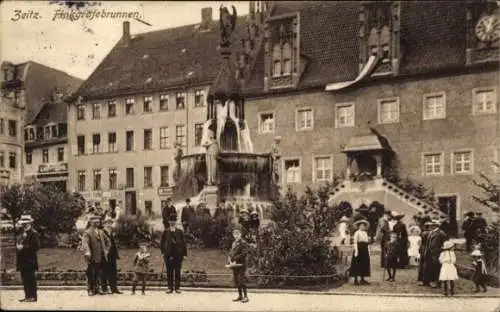 Ak Zeitz im Burgenlandkreis, Fountain, Gebäude im Hintergrund, Menschen in m Kleid, Schwarz-Weiß-