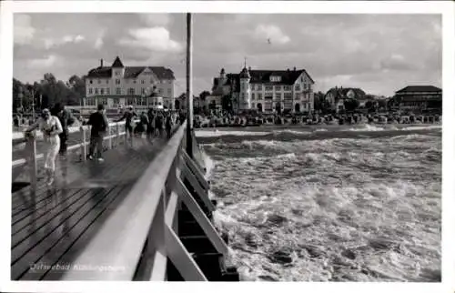 Ak Ostseebad Kühlungsborn, Ostseebad  Spaziergänger auf der Seebrücke, Wellen, Gebäude