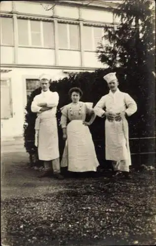 Foto Ak Köche und Köchin vor einem Gebäude, Portrait