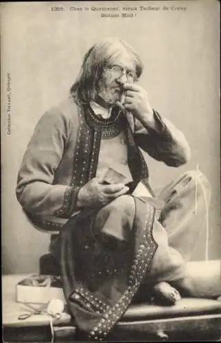 Ak Coray Finistère, Ein alter Schneider aus Coray sitzt auf dem Boden und schneidet Stoff zu.