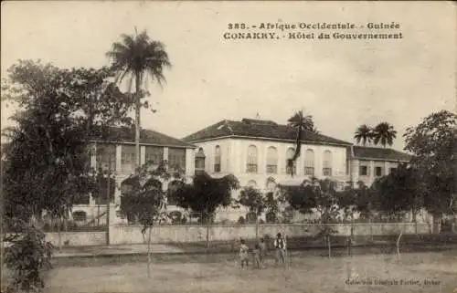 Ak Conakry Guinea, Hôtel du Gouvernement, palmengesäumtes Gebäude, historische Postkarte, Afrika