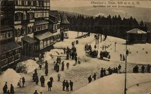 Ak Oberhof im Thüringer Wald, Sportleben auf dem Denkmalsplatz, Winterlandschaft, Menschen, Gebäu