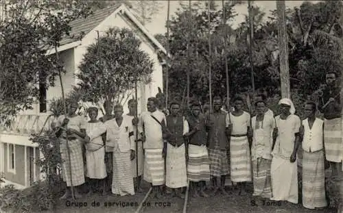 Ak São Tomé St. Thomé, Gruppe von Menschen, im Freien, mit Holzstöcken, Häuser im Hintergrund,...