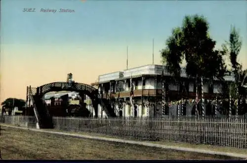 Ak Suez Ägypten, Bahnhof, Brücke, Gebäude, festliche Dekoration, Palmen