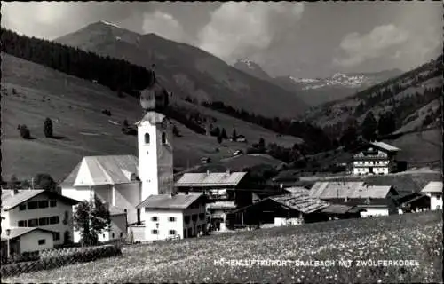 Ak Saalbach in Salzburg, Dorfansicht, Kirche, Zwoelferkogel mit Bergen im Hintergrund