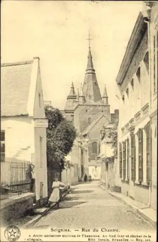 Ak Soignies Wallonien Hennegau, Straße mit alten Häusern, Kirchturm im Hintergrund, ruhige Atmosp