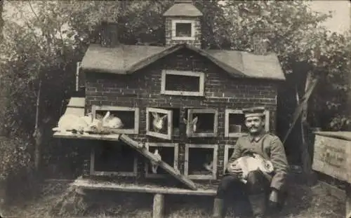 Foto Ak Deutscher Soldat in Uniform, Häuschen mit Kaninchen
