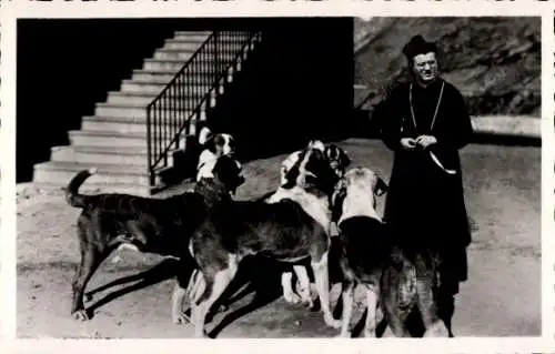 Ak Kanton Wallis, Hospice du Grand St-Bernard, Ein Mönch steht vor einer Treppe und vier Bernh...