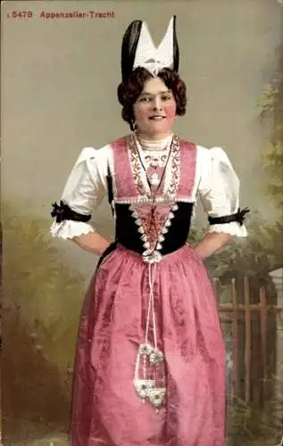 Ak Appenzell Stadt Kanton Innerrhoden, Eine junge Frau in Appenzeller Tracht steht vor einem Z...