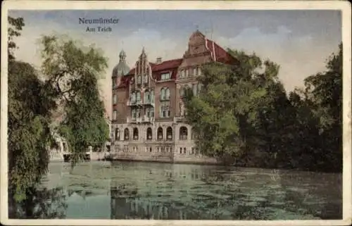 Ak Neumünster in Holstein,  Gebäude am Teich, malerische Wasserlandschaft