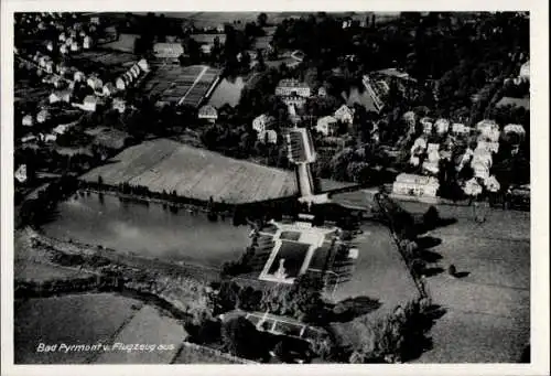 Ak Bad Pyrmont in Niedersachsen, Luftaufnahme von  Stadtansicht, Teich, Grünflächen, Häuser