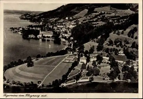 Ak Tegernsee in Oberbayern, Luftaufnahme des Tegernsees, idyllische Landschaft, zahlreiche Bäume,