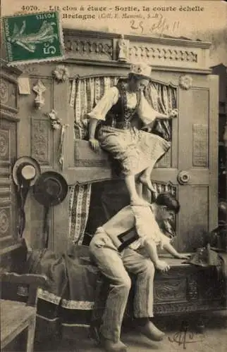 Ak Bretagne, Costumes Bretons, bretonische Trachten, Frau steigt aus einem Hochbett, ein Mann ...