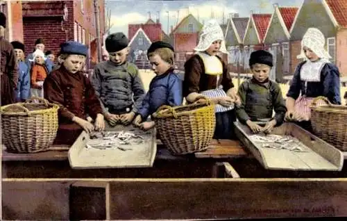 Ak Volendam Nordholland Niederlande, Kinder in traditioneller Kleidung sortieren Fische in Körbe