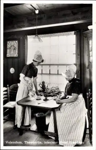 Ak Volendam Nordholland Niederlande, Frauen im traditionellen Kostüm, Inneneinrichtung, Tisch ...