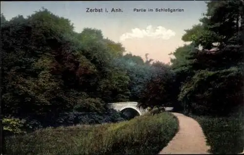 Ak Zerbst in Anhalt, Schöne Parklandschaft, Brücke, bewaldeter Weg, Himmel mit Wolken