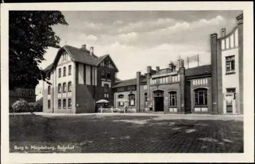 Ak Burg bei Magdeburg, Bahnhof, Gebäude im n Stil, gepflasterte Straße, Schatten von Bäumen
