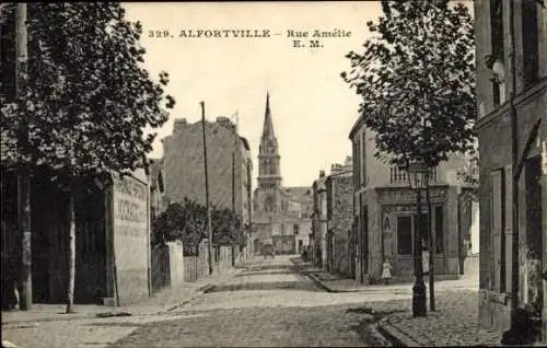 Ak Alfortville Val de Marne, Vielbaumbewachsene Straße, Kirche im Hintergrund, alte Gebäude