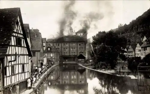 Ak Calw im Schwarzwald, Fabrikanlage im Brand, Gebäude raucht, Fluss im Vordergrund, Bäume