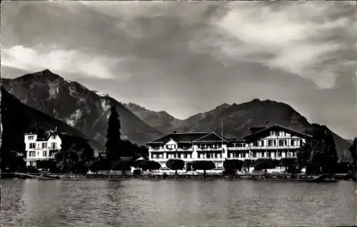 Ak Bönigen Kanton Bern, Historische Gebäude am Brienzersee, Berge im Hintergrund