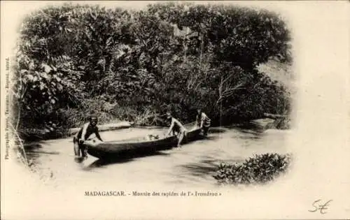 Ak Madagaskar Madagascar, Zwei Männer in einem Boot, Flusslandschaft, dichte Vegetation