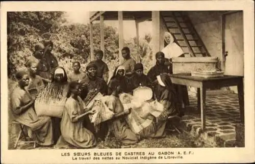 Ak Libreville Gabun, Gruppenszene mit Frauen, Arbeit mit Nattern, Gebäude im Hintergrund